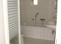 Betegelde badkamer met bad, wastafel en toilet