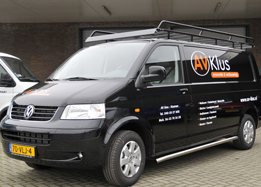 De zwarte bedrijfswagen van AV-Klus met belettering